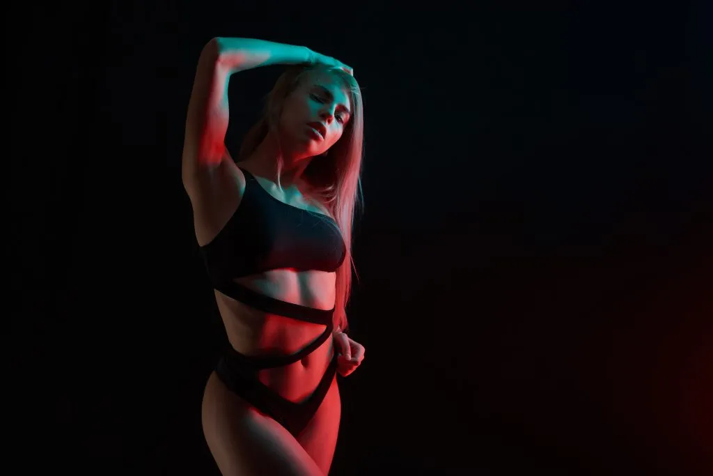 Pole Dance Mädchen mit perfektem Körper in schwarzen sexy Dessous. Nachtclub Konzept